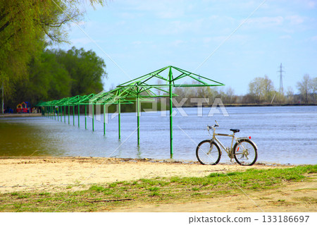 Empty beach awnings flooded with water during flood in spring and parked bicycle 133186697