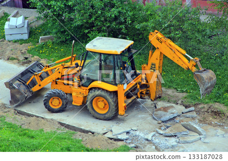 Tractor dismantles old road. Special equipment for road repair at work 133187028