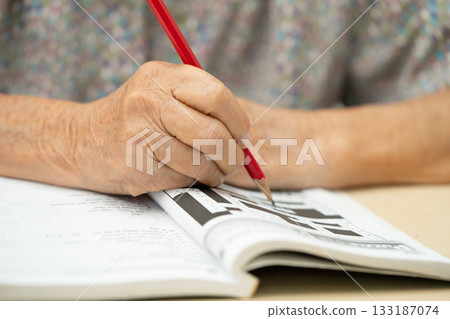 Asian elderly woman playing puzzle game to practice skill. 133187074