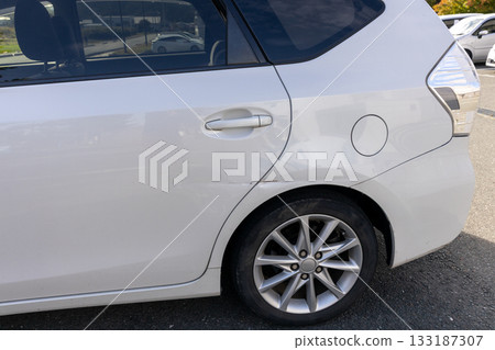 Dent near the rear tire of a car Dent near the rear tire of a car 133187307