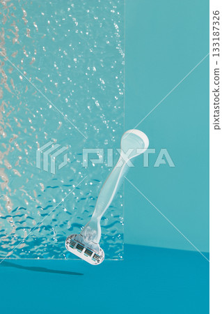 Minimalist elegance: Razor in sharp relief against a bold blue backdrop with dramatic shadows Minimalist elegance: Razor in sharp relief against a bold blue backdrop with dramatic shadows 133187326