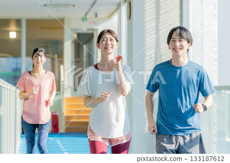 Men and women running on an indoor track 133187612