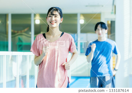 Woman running on an indoor track Woman running on an indoor track 133187614