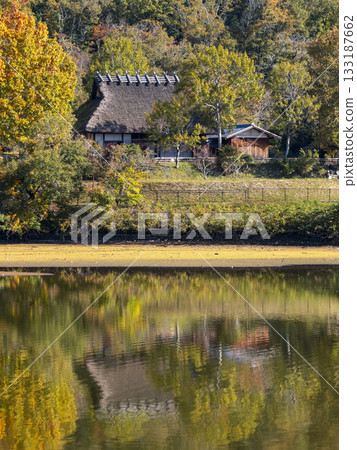 Autumn scenery: An old thatched roof house standing by the water Autumn scenery: An old thatched roof house standing by the water 133187662