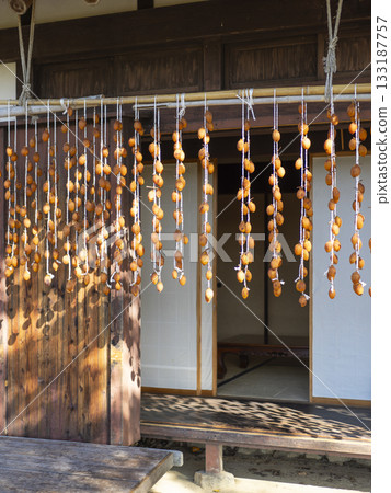 老房子屋簷下掛著乾柿子 133187757