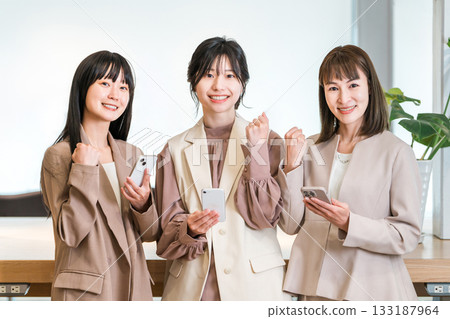 一位女商人的老闆和下屬在辦公室擺姿勢豎起大拇指。 133187964