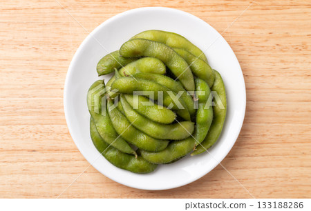 Boiled Edamame beans (Japanese soybeans) on white plate, Table top view 133188286