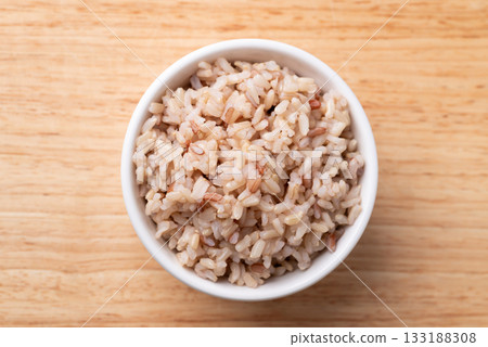 Cooked Thai brown rice in a bowl on wooden background, Healthy eating Cooked Thai brown rice in a bowl on wooden background, Healthy eating 133188308
