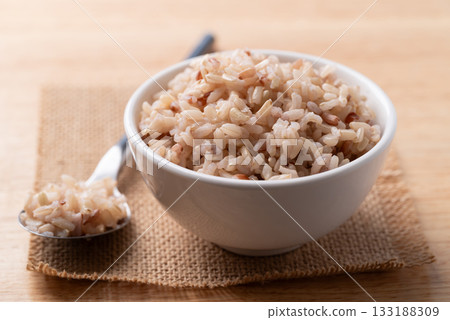 Cooked Thai brown rice in a bowl with spoon, Healthy eating 133188309