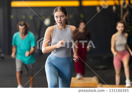 Young woman stepping on box at Crossfit workout Young woman stepping on box at Crossfit workout 133188365