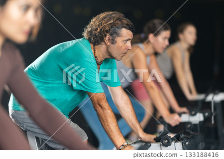 man doing exercises on a bicycle simulator during a crossfit workout 133188416