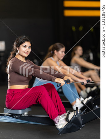 Latina woman doing an exercise on a rowing machine 133188458