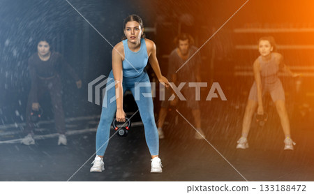 Young woman doing kettlebell thrusts in Crossfit training 133188472