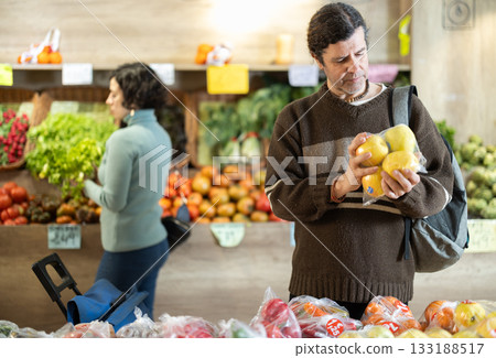 Adult man choosing apples in plastic bag 133188517