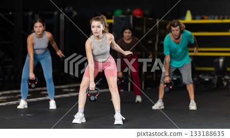 Young woman doing exercises with kettlebell 133188635