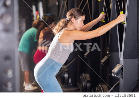 Woman doing exercises on ski ergometer simulator 133188691
