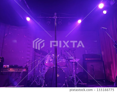Drums and amplifiers on a purple lit stage 133188775
