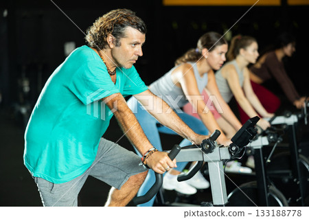 man doing exercises on a bicycle simulator during a crossfit workout 133188778