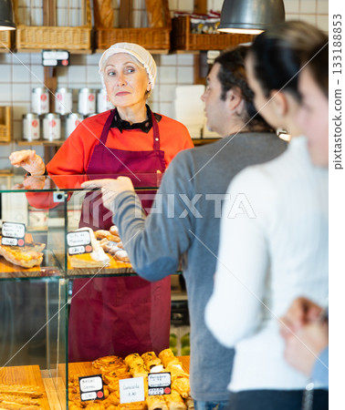 People place order at bakery, buy sweet pastries in cafeteria, senior woman worker serving people People place order at bakery, buy sweet pastries in cafeteria, senior woman worker serving people 133188853