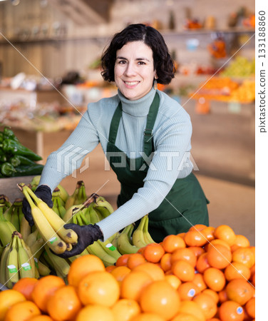 Woman shop seller puts banana goods on display case 133188860