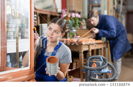 Professional furniture restorer renewing vintage chest of drawers in workshop Professional furniture restorer renewing vintage chest of drawers in workshop 133188874