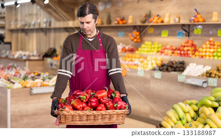 Adult man seller with basket of bell peppers Adult man seller with basket of bell peppers 133188987