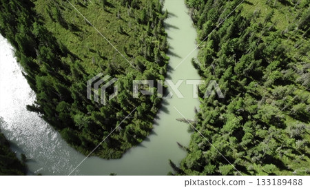 Turquoise river flowing through lush green valley. Media Turquoise river flowing through lush green valley. Media 133189488