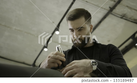 Professional barber shaving customer's hair with trimmer. Clip Professional barber shaving customer's hair with trimmer. Clip 133189497