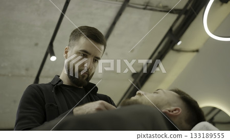 Barber giving a precise haircut with a trimmer. Clip Barber giving a precise haircut with a trimmer. Clip 133189555
