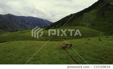 People horseback riding in a green mountain valley. Media People horseback riding in a green mountain valley. Media 133189638