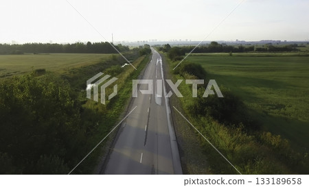 Aerial view of countryside road through green fields. Clip 133189658