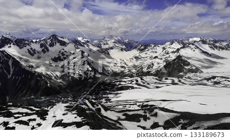 Dramatic clouds moving over snowy mountain range 133189673