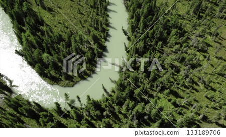 Turquoise river flowing through lush green forest and rocky mountains. Media Turquoise river flowing through lush green forest and rocky mountains. Media 133189706