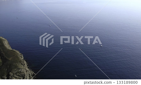 Aerial view of fishing boats sailing in deep blue ocean near the coast. Media Aerial view of fishing boats sailing in deep blue ocean near the coast. Media 133189800