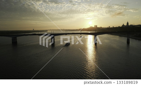 River ferry navigating under a bridge during sunrise. Clip 133189819