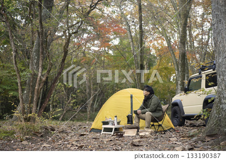 一位男子在秋季享受獨自露營的樂趣。 一位男子在秋季享受獨自露營的樂趣。 133190387