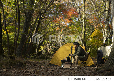 一位男子在秋季享受獨自露營的樂趣。 一位男子在秋季享受獨自露營的樂趣。 133190388