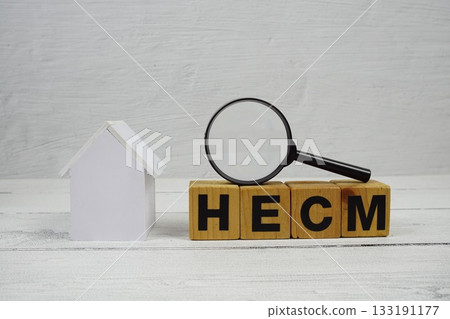 HECM Home Equity Conversion Mortgage alphabet letters with house model and magnifying glass on wooden background 133191177
