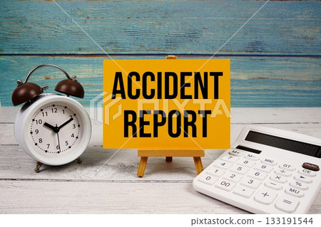 Accident Report text written on paper card with calculator and alarm clock on wooden background Accident Report text written on paper card with calculator and alarm clock on wooden background 133191544