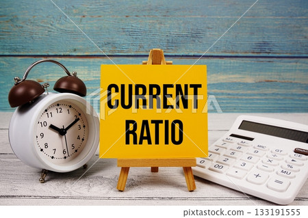 Current Ratio text written on paper card with calculator and alarm clock on wooden background Current Ratio text written on paper card with calculator and alarm clock on wooden background 133191555