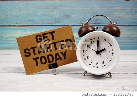 Get Started Today text written on paper card with alarm clock on wooden background 133191785