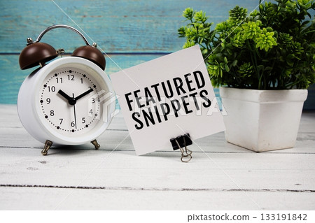 Featured Snippets text written on paper card with alarm clock on wooden background 133191842
