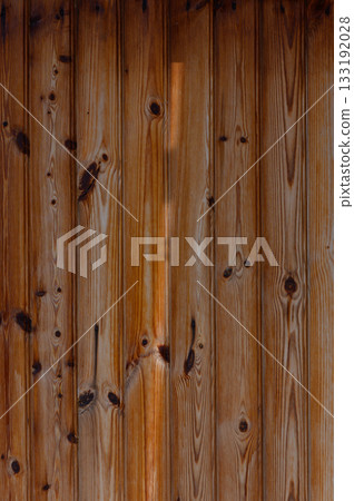 Close-up view of rustic wooden planks showcasing natural patterns and textures under warm light Close-up view of rustic wooden planks showcasing natural patterns and textures under warm light 133192028