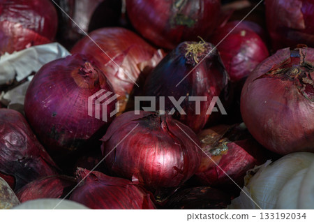 Colorful assortment of fresh red onions displayed at a bustling market during the vibrant afternoon hours in late summer Colorful assortment of fresh red onions displayed at a bustling market during the vibrant afternoon hours in late summer 133192034