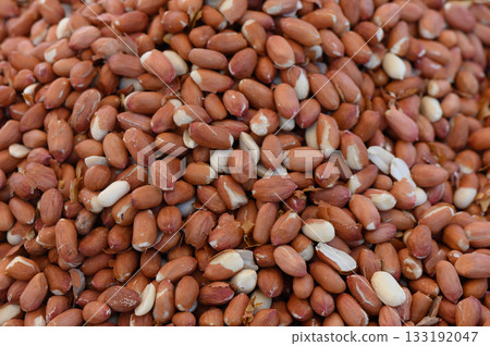 Peanuts scattered in abundance, showcasing their rich texture and earthy hues in natural light Peanuts scattered in abundance, showcasing their rich texture and earthy hues in natural light 133192047