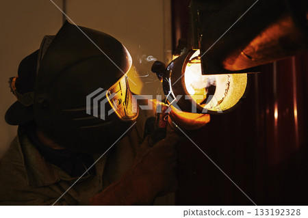 Male in face mask welds with welding 133192328