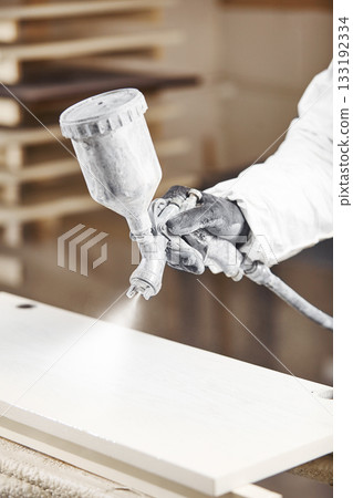 Man working with paint spray gun, airless spraying to wood 133192334