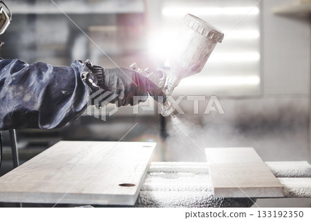 Staining wood with white spray gun. Application of flame retardant ensuring fire protection, airless spraying device. Staining wood with white spray gun. Application of flame retardant ensuring fire protection, airless spraying device. 133192350