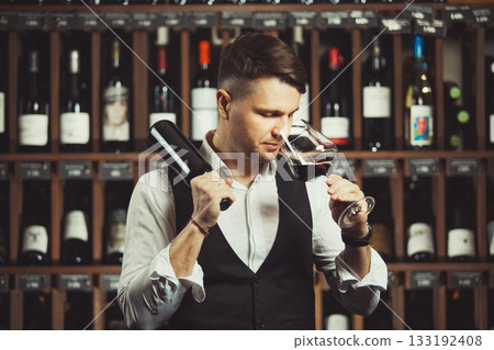 Bokal of red wine on background, male sommelier appreciating drink 133192408