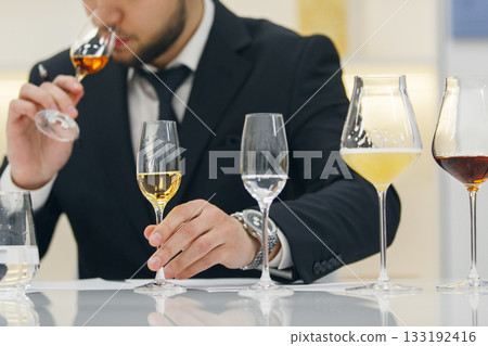 Professional sommelier sniffing various alcoholic drink during blind tasting. Sommelier exam to study different wine and whiskey. Professional sommelier sniffing various alcoholic drink during blind tasting. Sommelier exam to study different wine and whiskey. 133192416